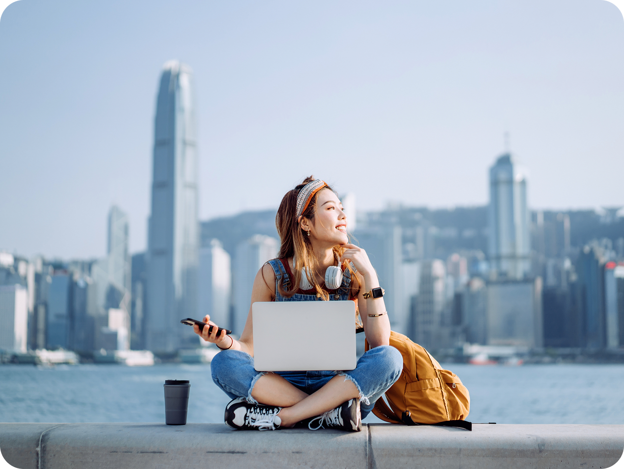 Woman with laptop by Hong Kong harbor